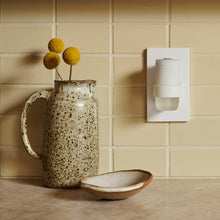Plug-in oil diffuser warmer attached to wall outlet