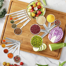 Stainless measuring cups and spoons set arranged on a cutting board with ingredients