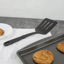 Black nylon slotted spatula and spoon set on countertop, three-piece kitchen utensils
