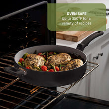 Black ceramic non-stick sauté pan in oven with cooked food and side handles