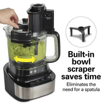 Food processor with clear bowl and built-in scraper, holding green puree while blending