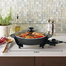 Black electric skillet with glass lid and removable temperature control, on countertop