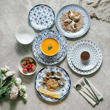 Ceramic dinnerware set with blue-and-white plates and bowls, top view with food