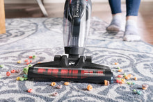 Stick vacuum floor brush on a blue rug with clear dust bin, corded