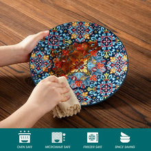 Blue floral patterned ceramic plate with red bowl inside, held by hands