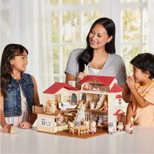 Mini dollhouse playset held by adults and children, red roof and many rooms visible