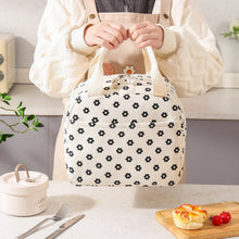 Beige lunch bag with black flower print, open top zipper and insulated lining