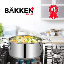 Stainless steel stockpot with lid cooking contents on a gas stove