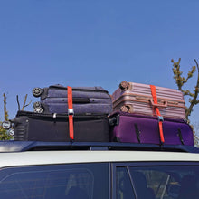 Red tie-down straps with metal buckles and S-hooks securing rooftop cargo
