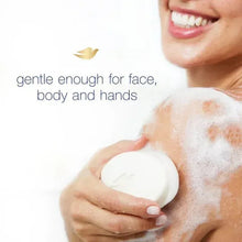 White Dove beauty bar soap held in a hand, with lather on skin