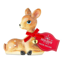Sitting deer tabletop decoration with red bow, gold bell, and Holiday Time tag
