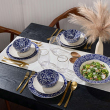 Blue and white ceramic dinnerware set on table with bowls and plates