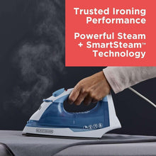 Blue steam iron in use, angled soleplate over fabric