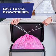 Pink drawstring trash bag shown being closed over a kitchen bin