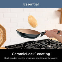 Black skillet on gas range with beige nonstick interior and side handles