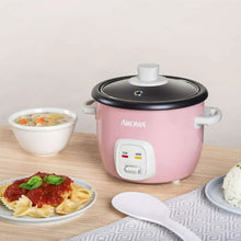 Pink 4-cup rice cooker with black lid and white front control panel on countertop