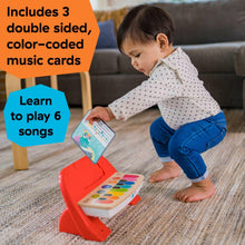 Red and white baby piano toy with colorful music cards and panel keys