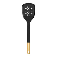 Black silicone slotted turner with perforated head and gold handle end