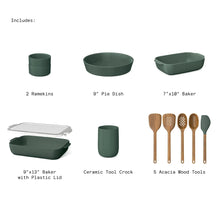 Assorted green ceramic bakeware pieces and acacia wood tools on layout