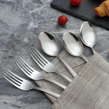 Stainless steel soup spoons and forks, mirror-polished reflective serving cutlery