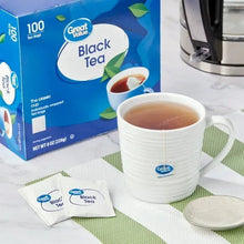 Black tea bags box and brewed cup beside unopened individual tea bags