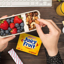 Juicy Fruit Original gum pack held between hands with a fruit snack tray