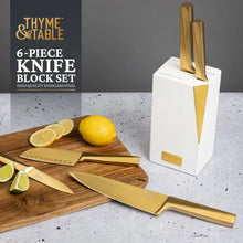Gold knives with a white slim knife block, several blades on a cutting surface