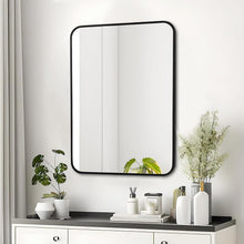Bathroom wall mirror with black frame and rounded corners above countertop essentials.