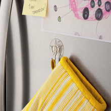 Clear suction cup hook hanging a yellow striped kitchen towel on a wall