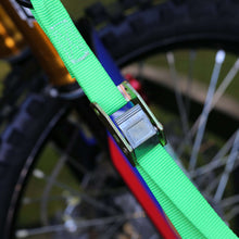 Green cam buckle strap hardware on a tie-down strap, close-up on metal adjuster