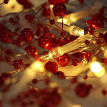 Red berry-beaded garland close-up with warm white LEDs and glowing bead clusters