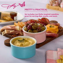 Two round ceramic ramekins, one pink and one blue, filled with dips for serving.