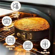 Black round springform cake pan on oven rack with baked cake surface.