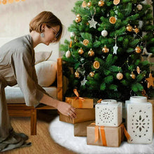 White faux fur Christmas tree skirt draped under a decorated Christmas tree, soft shag edge