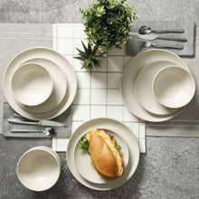 Cream matte dinnerware set on table: bowls, plates, and cups