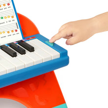 Mini musician's piano with color-coded keys and a hand pressing the keys