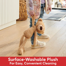 Beige teddy bear plush with floppy legs and arms, standing on the floor