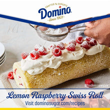 Powdered sugar-dusted roll with white frosting and red berries, hand sifter spreading sugar