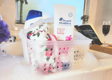 White frosted plastic shower caddy with handle filled with bath items and bottles