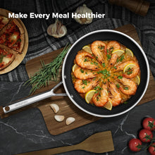 Black nonstick frying pan with shrimp and lemon slices, stainless-steel handle