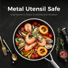 Black nonstick frying pan with seafood and vegetables, stainless-steel handle