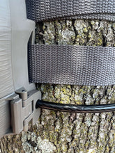 Trail camera cable lock attached to a tree with gray mounting strap