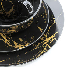 Black porcelain serving plate with gold marble veining, glossy rim and raised edge
