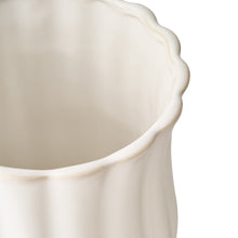 White stoneware utensil holder close-up of scalloped rim and side curves
