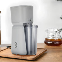 Single serve iced coffee maker with open top and clear cup on a counter