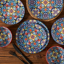 Assorted ceramic plates with blue floral mosaic patterns and decorative borders