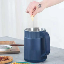 Blue electric spice grinder receiving ingredients from above into the stainless top