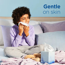 Facial tissue use: person holding a white tissue and tissue box on bed