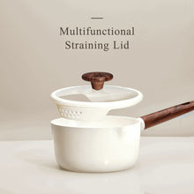 White ceramic saucepan with multifunctional straining lid and wooden-style handle