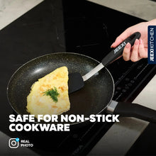 Black silicone spatula flipping food in a nonstick frying pan